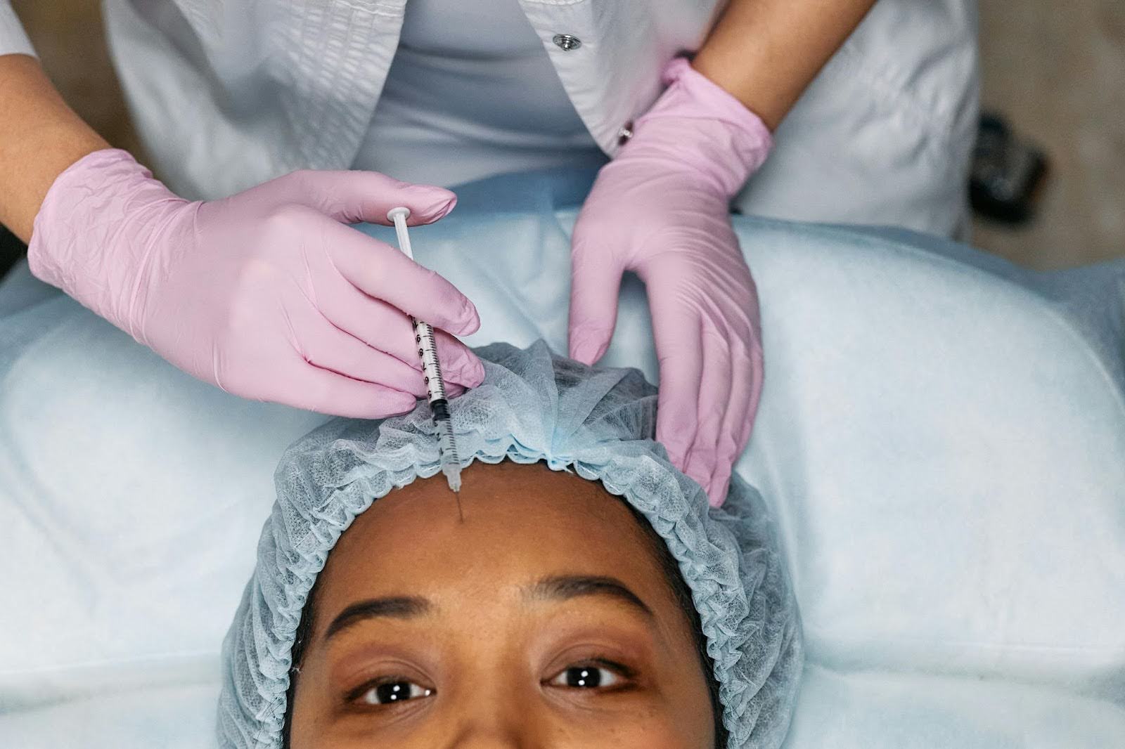 woman receiving injection in her forehead by trained medical professional